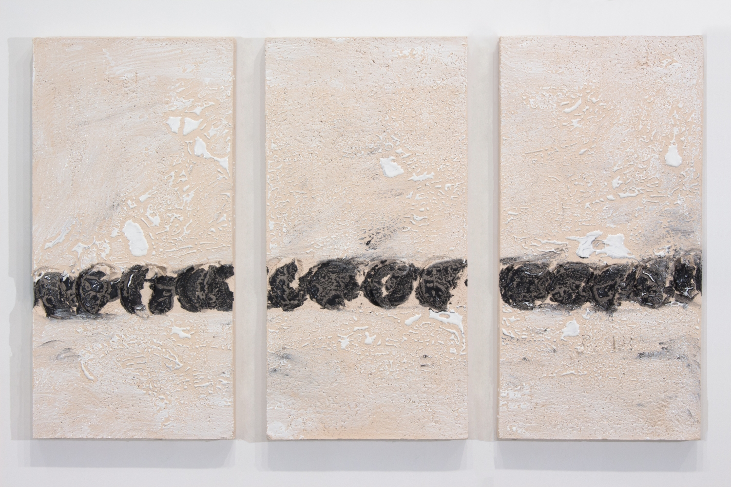 triptych of white ceramic panels with a line of black circular gouges across the lower half of each panel