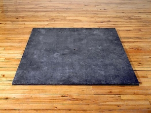 black square sculpture on a hardwood floor