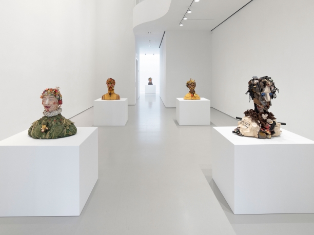 gallery installation view with five large sculptures of ceramic busts on white pedestals