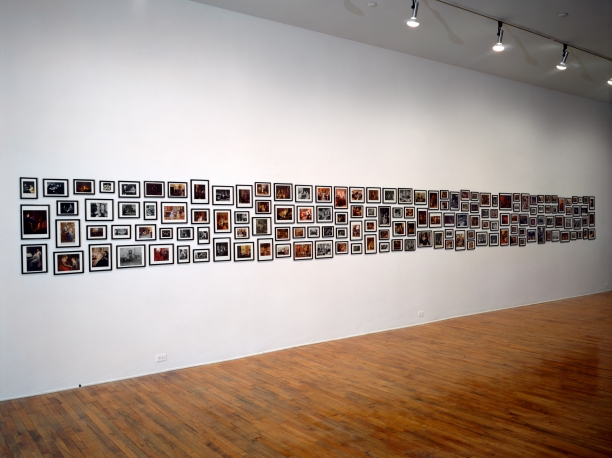 gallery installation view with a large suite of framed photographs